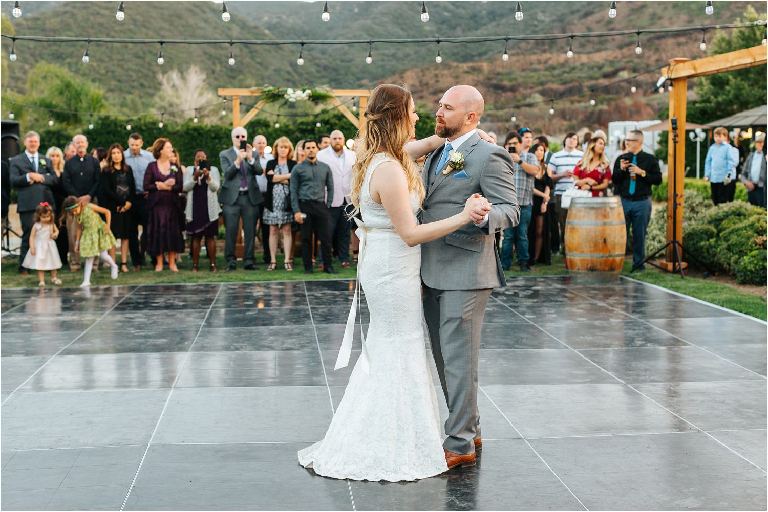 Family and friends watch as bride and groom share their first dance as husband and wife - https://brittneyhannonphotography.com